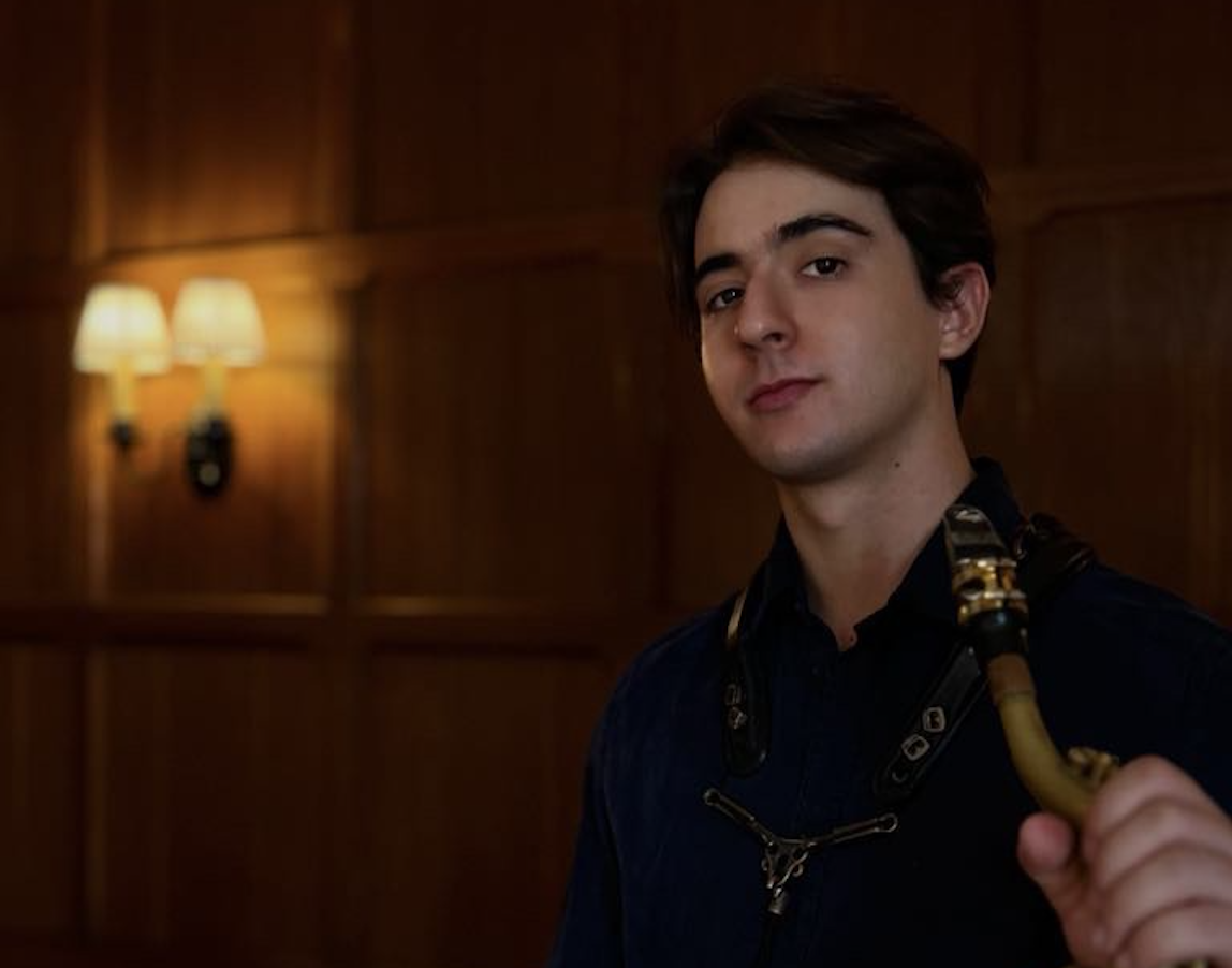 Adam Aronesty holding a saxophone.