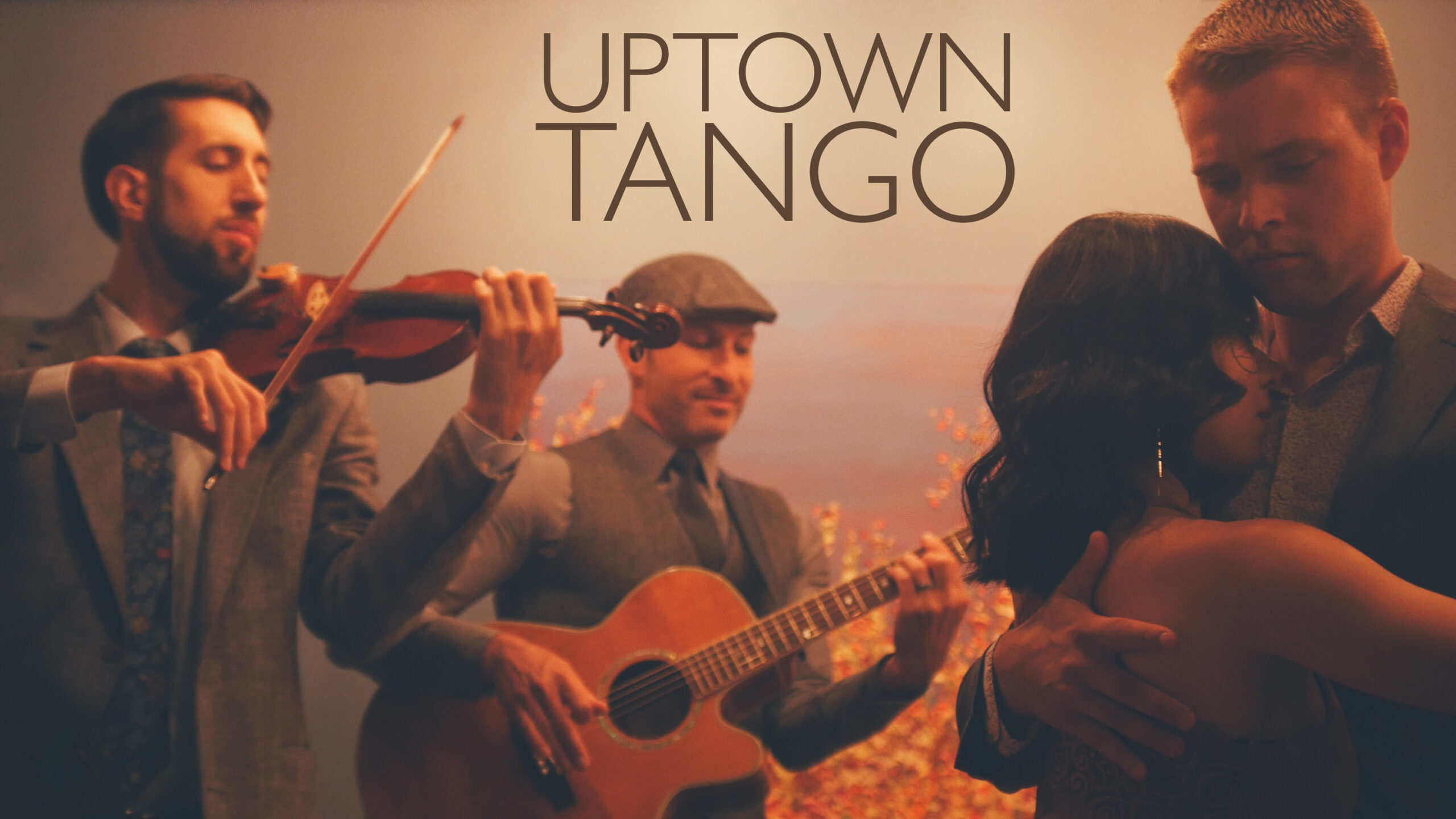 Uptown Tango band featuring a guitarist and violinist playing while a couple dances.