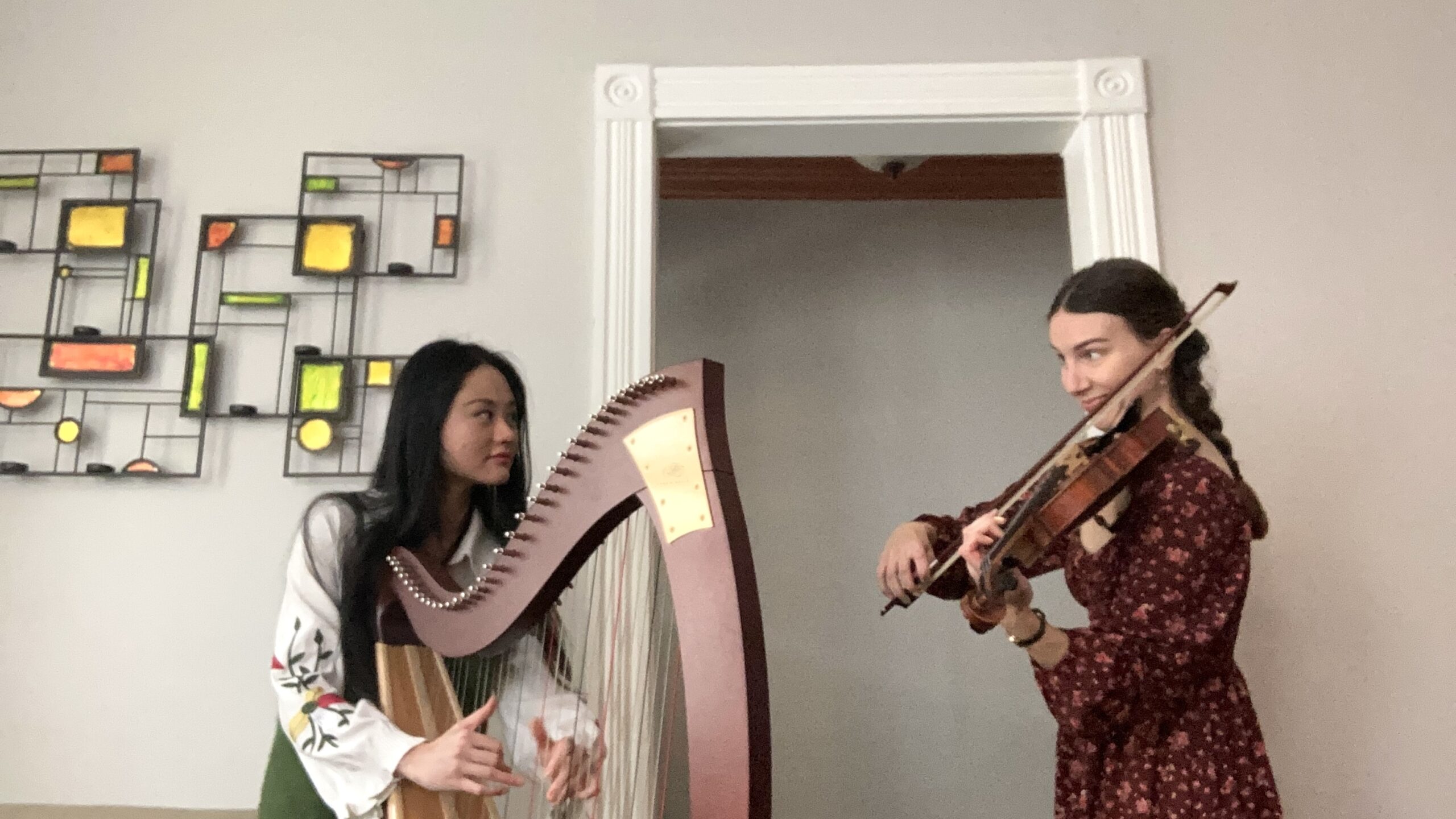 Alyssa Rodriguez and Sunshine Quan playing the harp and fiddle.